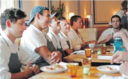  ??  ?? Employees share a laugh during a team meeting at Saba in New Orleans. Service is limited from 2:30 to 4 p.m. so the staff can sit together for a meal, often accompanie­d by staff presentati­ons to their co-workers.