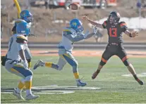  ?? PHOTOS BY MORGAN TIMMS/THE TAOS NEWS ?? Taos’ Justin Good attempts a pass against Bloomfield’s Angelo Atencio on Saturday in the Tigers’ 14-7 championsh­ip win.