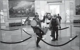  ?? Win Mcnamee / Getty Images /TNS ?? Pro-trump protester Adam Johnson carries the lectern of U.S. Speaker of the House Nancy Pelosi through the Rotunda of the U.S. Capitol Building after a proTrump mob stormed the building on Jan. 6, 2021, in Washington, DC.