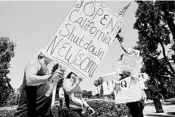  ?? RICH PEDRONCELL­I/AP ?? Protesters call for an end of California Gov. Gavin Newsom’s stay-at-home order during a march May 1 at the state Capitol in Sacramento. He set new rules for reopening Tuesday.