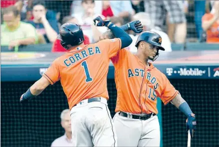  ?? Jason Miller Getty Images ?? HOUSTON’S CARLOS CORREA celebrates with Martin Maldonado after hitting a three-run home run in the eighth inning.