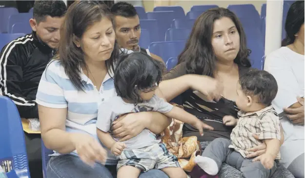  ?? PICTURE: GETTY IMAGES ?? 0 Mothers and children wait to be assisted by volunteers in a humanitari­an centre in the border town of Mcallen, Texas