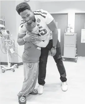  ?? Karen Warren photos / Houston Chronicle ?? Texas A&amp;M defensive end Myles Garrett made it a point to spend time with each of the M.D. Anderson patients he visited Friday, such as 12-year-old Damon Billeck.