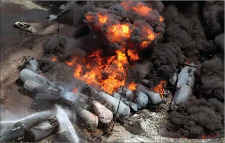  ?? The Canadian Press ?? Smoke rises from railway cars that were carrying crude oil after derailing in downtown Lac-Megantic, Que., on July 6, 2013. The derailment that killed 47 people and destroyed part of the town.