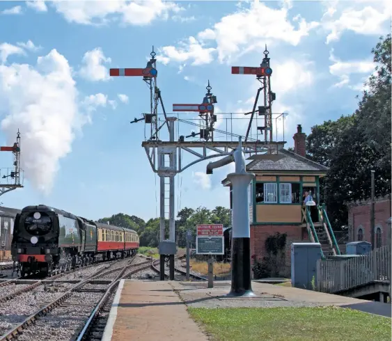  ?? JON BOWERS ?? Visiting ‘Spam Can’ No. 34092 City of Wells heads north into Horsted Keynes on July 10 2017, with the recently restored ‘Elephant Van’ just visible to the left. Behind it is the early 2000s extension to the Carriage & Wagon workshop adjoined to the original structure. The remaining stub of the Ardingly branch trails away to the right, with starter signals already in place for the ‘one day if…’