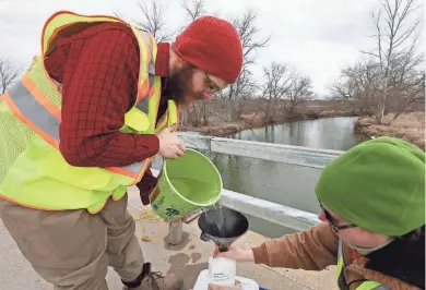  ?? RICK WOOD / MILWAUKEE JOURNAL SENTINEL ?? Josh Carlson and Laura Schulz collect a water sample from the Root River in Franklin. They are part of a team from the University of Wisconsin-Parkside checking the river’s health for the City of Waukesha. See more at jsonline.com/news.