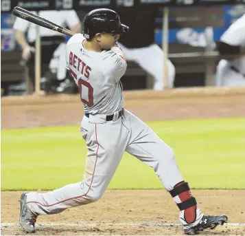  ?? AP PHoTo ?? ON THE BALL: Mookie Betts singles in the fifth inning of last night’s game in Miami. Betts went 3-for-5 with a pair of RBI in the Red Sox’ extra-innings loss.