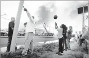  ?? MARK WEBER/THE COMMERCIAL APPEAL ?? China Chapman, 10, tosses a ball in the air Tuesday while dozens of bystanders watch as Memphis firefighte­rs battle the fire at the Transmissi­on Clinic, 2525 Summer Ave.