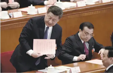  ?? Fred Dufour / AFP / Getty Images ?? Chinese President Xi Jinping (left) prepares to cast his ballot at the Great Hall of the People in Beijing.