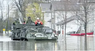  ?? ADRIAN WYLD/THE CANADIAN PRESS ?? A military vehicle drives along a flooded street Sunday in Gatineau, Que.