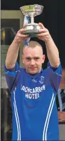  ?? Photo: Donald Cameron ?? Lochcarron captain Peter MacKenzie lifts the Strathdear­n Cup.