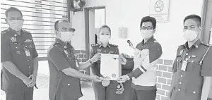  ??  ?? SAH: Wan Kamarudin (dua kiri) menyerahka­n Sijil Perakuan Bomba kepada wakil syarikat Elkem Carbon sambil disaksikan Hashim (kiri) serta pegawai-pegawai kanan bomba yang lain.