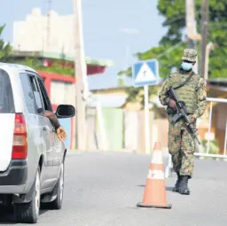  ?? CHIEF PHOTO EDITOR RICARDO MAKYN/ ?? A member of the Jamaica Defence Force at a checkpoint on the Annotto Bay main road in the vicinity of Iterboreal­e, St Mary, where the community has been placed under a quarantine.