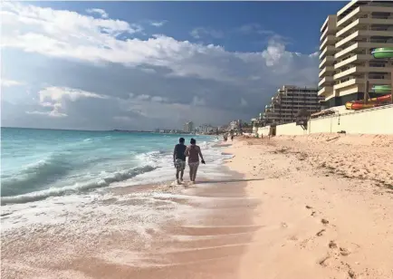  ?? DAWN GILBERTSON/USA TODAY ?? A couple stroll on the beach in the hotel zone in Cancun, Mexico