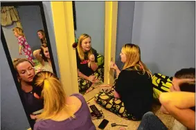  ??  ?? Friends, from left, Hailey Carr, Kelsey Smith and Jessica Whitman apply makeup as Kelsey’s daughter, Hadley, 2, and her sister Erica Johnson play on the bed Jan. 6 at Kelsey’s home in Groton. The women were going to a “Halfway Party” for the wives and...