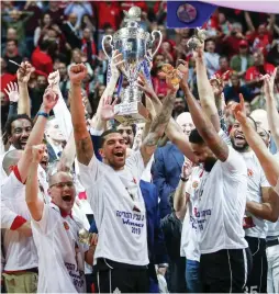  ?? (Danny Maron) ?? HAPOEL JERUSALEM celebrates on the court with the trophy following its victory over Maccabi Rishon Lezion in last week’s State Cup final in the capital.