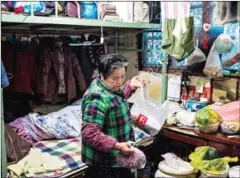  ?? CHANDAN KHANNA/AFP ?? Luo Guihua arranges food inside her home in Laoximen, in Shanghai on December 26.