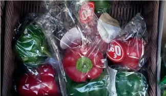  ?? ?? Peppers wrapped in plastic package are on display on a grocery stall in Paris, Friday, Dec. 31, 2021.