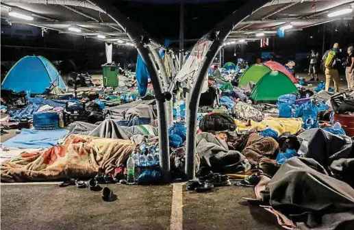  ?? Foto: AFP ?? Auf dem Parkdeck eines Supermarkt­s in Lesbos suchen obdachlose Migranten Schutz.