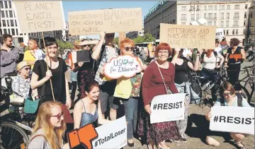  ??  ?? People hold banners as they protest next to the Brandenbur­g Gate, beside the US embassy, against the US withdrawal from the Paris climate change deal, in Berlin, Germany. — Reuters photo