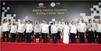  ??  ?? MANILA: Leaders and their spouses wave as they pose for a group photo at the welcome dinner for the Asia-Pacific Economic Cooperatio­n (APEC) summit in Manila yesterday. — AFP