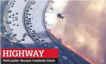  ??  ?? Helicopter douses roadside blaze