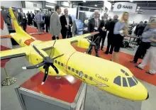  ?? THE CANADIAN PRESS FILES ?? Delegates pass a model of the Airbus C295 fixed wing search and rescue aircraft at a trade show in Ottawa in this file photo.