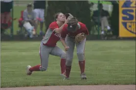  ?? JEN FORBUS — FOR THE MORNING JOURNAL ?? Elyria’s shortstop Madison Olszewski ducks to allow left fielder Mallory Phares to make the catch for an out in 2019.