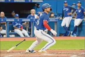  ?? Jon Blacker / Associated Press ?? Blue Jays Kevin Smith, a Columbia High grad, hits a single against the Tigers in the third inning last Friday in Toronto for his first big league hit.