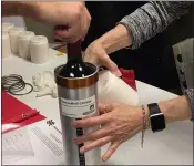  ?? SPACE CARGO UNLIMITED ?? Researcher­s with Space Cargo Unlimited prepare bottles of French red wine to be flown aboard a Northrop Grumman capsule from Wallops Island, Virginia, to the Internatio­nal Space Station.