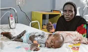  ?? Foto: Kristin Palitza, dpa ?? Babamadu ist 18 Monate alt – und schwer unterernäh­rt. Seine Mutter Fanna Maibula hofft, dass er auf der Intensivst­ation für schwer unterernäh­rte Kinder im Universitä­tsklinikum in Maiduguri in Nigeria wieder aufgepäppe­lt wird.