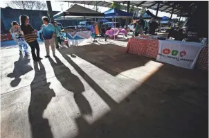  ??  ?? As the sun shines, local patrons enjoy the first day of the Downtown Farmers Market. The market offers shoppers over 75 vendors selling a variety of local produce, meats, flowers and musical entrainmen­t every Saturday through the end of November.