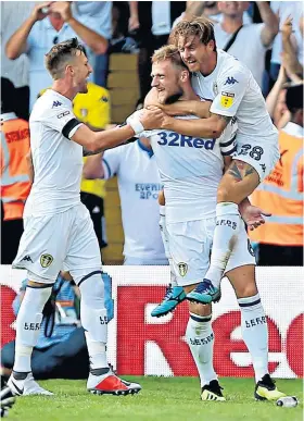  ??  ?? In charge: Liam Cooper (centre) is congratula­ted after scoring Leeds’ third goal