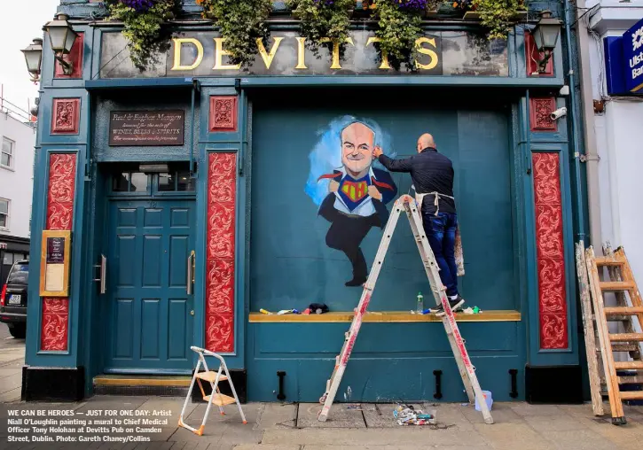 ??  ?? WE CAN BE HEROES — JUST FOR ONE DAY: Artist Niall O’Loughlin painting a mural to Chief Medical Officer Tony Holohan at Devitts Pub on Camden Street, Dublin. Photo: Gareth Chaney/Collins