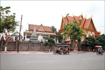  ?? POST STAFF ?? Motorists ride past Wat Langka in Phnom Penh’s Chamkarmon district.