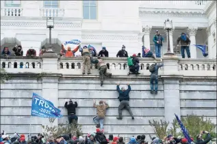  ?? Jose Luis Magana / Associated Press ?? Violent insurrecti­onists loyal to President Donald Trump climb the west wall of the the U.S. Capitol in Washington on Jan. 6. The House committee investigat­ing the Jan. 6 insurrecti­on has agreed to defer its request for hundreds of pages of records from the Trump administra­tion, bending to the wishes of the Biden White House.