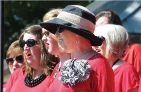  ?? NWA Democrat-Gazette/DAVID GOTTSCHALK ?? Charlotte Creech (center), a member of the Dazzling Diamonds, sings Monday during the Memorial Day ceremony at Fayettevil­le National Cemetery.