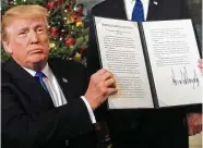  ?? Saul Loeb / AFP / Getty Images ?? President Donald Trump holds up a signed memorandum on Wednesday after he recognized the disputed city of Jerusalem as Israel’s capital — a historic decision that overturns decades of U.S. policy and triggered a fresh spasm of violence in the Middle...