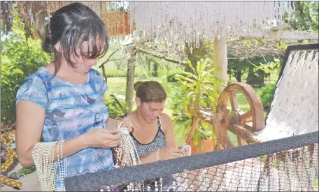  ??  ?? Numerosos jóvenes apoyan a Koki Ruiz en la tarea de clasificar por colores los rosarios donados para el retrato de Chiquitung­a.