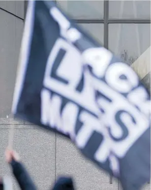  ??  ?? National Guard members watch as a Black Lives Matter flag is flown near the