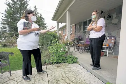  ?? Photos by Paul Sancya, The Associated Press ?? Lori Goldman, talks with a voter while canvassing in Troy, Mich., on Thursday. “You can be right all day, but if you’re not winning, what’s the point?” she said.