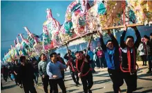  ??  ?? Villagers parading a dragon before burning it as an offering in Gutian village.