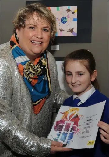  ??  ?? Kieran Clifford of Amnesty Internatio­nal presents Sarah Casey of Reeemer Girls School with the Best school entry award