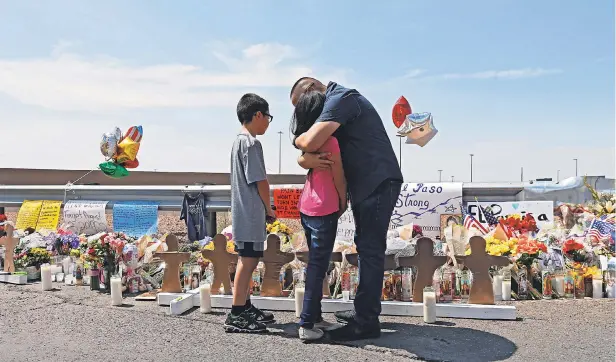  ?? LARRY W. SMITH/EPA-EFE ?? Visitors mourn at a makeshift memorial Monday outside the Walmart in El Paso, Texas, where a gunman opened fire on shoppers Saturday.