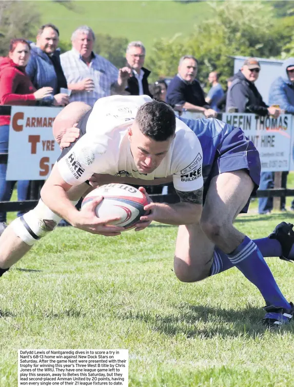  ??  ?? Dafydd Lewis of Nantgaredi­g dives in to score a try in Nant’s 68-13 home win against New Dock Stars on Saturday. After the game Nant were presented with their trophy for winning this year’s Three West B title by Chris Jones of the WRU. They have one league game left to play this season, away to Betws this Saturday, but they lead second-placed Amman United by 20 points, having won every single one of their 21 league fixtures to date.