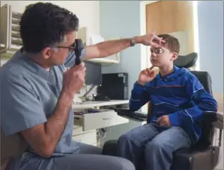  ?? SCOTT GARDNER, THE HAMILTON SPECTATOR ?? Dr. Kourosh Sabri examines Keyvan Mehta-Owens’ eye at McMaster Children’s Hospital.