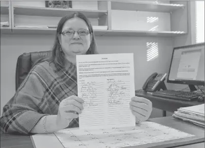  ?? NANCY KING/CAPE BRETON POST ?? Dayna Enguehard, Cape Breton District local president of the Nova Scotia Teachers Union, displays one of the petitions the NSTU is collecting with signatures of those opposed to the province’s plan to roll out changes to the education system outlined...