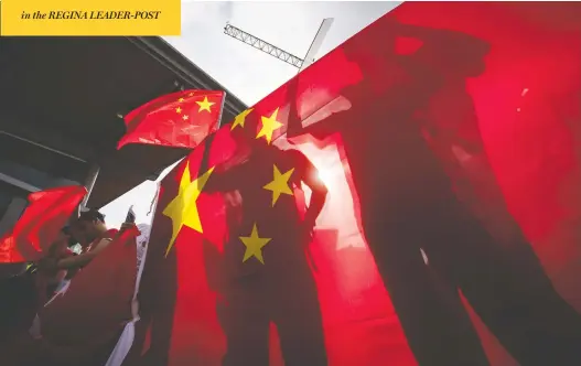  ?? DARRYL DYCK/THE CANADIAN PRESS ?? Pro-china counter-protesters cast shadows on a Chinese flag as they shout at Hong Kong anti-extraditio­n bill protesters holding a rally in Vancouver in August.