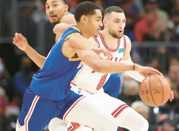  ?? JOHN J. KIM / CHICAGO TRIBUNE ?? Bulls guard Zach LaVine (8) defends Warriors guard Jordan Poole in the first quarter Friday at United Center. LaVine left early in the game after suffering a left knee injury. The Bulls lost to Golden State 138-96.