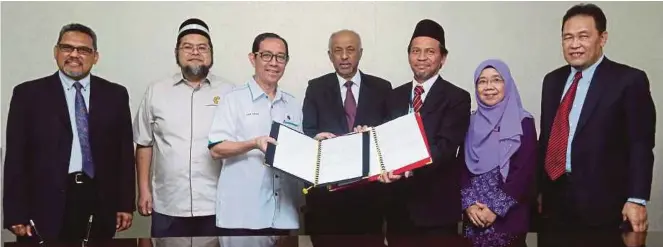  ?? [FOTO SALHANI IBRAHIM / BH] ?? Pertukaran dokumen
MOU antara Dzulkifli (tiga dari kiri) dan Wan Mohd Azizi (tiga dari kanan) pada majlis yang diadakan di UIAM
Kampus Gombak, baru-baru ini.